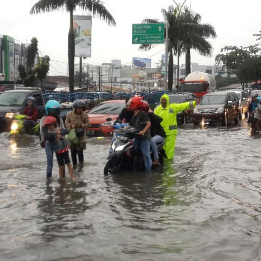 Polantas Bantu Pengendara Sepeda Motor Yang Melintasi Genangan Air Di Depan RS. Awal Bross